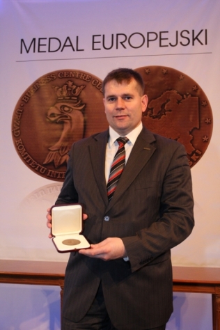 Grzegorz Jarzyński, prezes firmy Elpigaz, prezentuje przyznany Medal Europejski